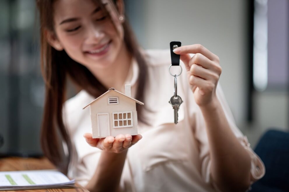 Once buyer purchase owner's title insurance she smiles with the key to home in hand