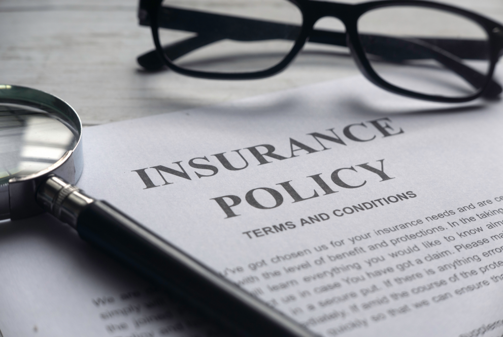 Title insurance policy document on a table along with a magnifying glass and a specs